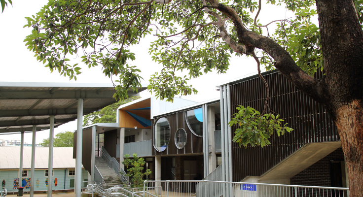 Landscape shot of the new modern building - K Block. A tree is in front of the building.